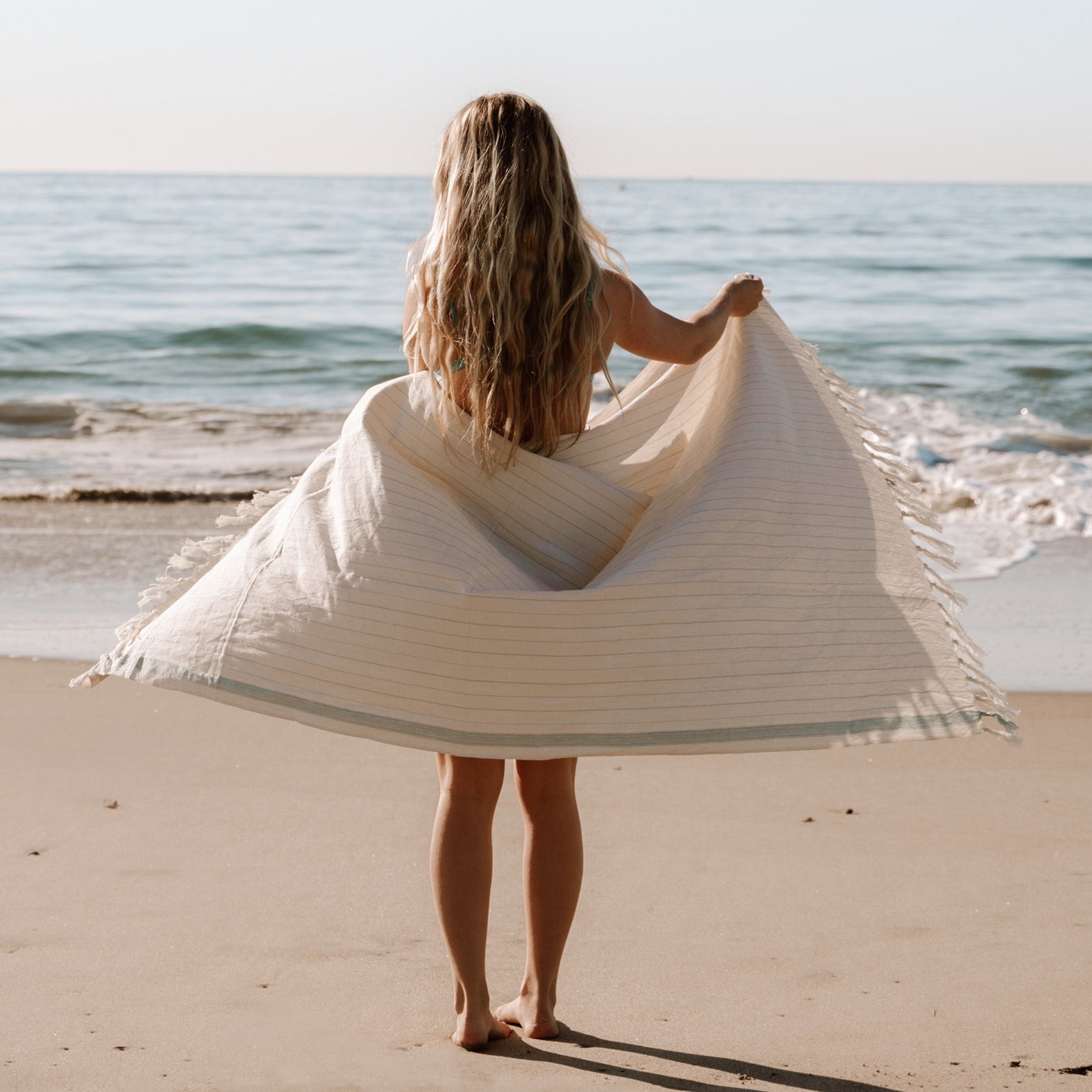 Beige and sea foam blue handwoven Turkish towel as a beach towel.